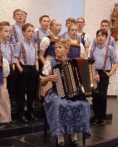 Kinder singend hinter 
				Akkordeonspielerin