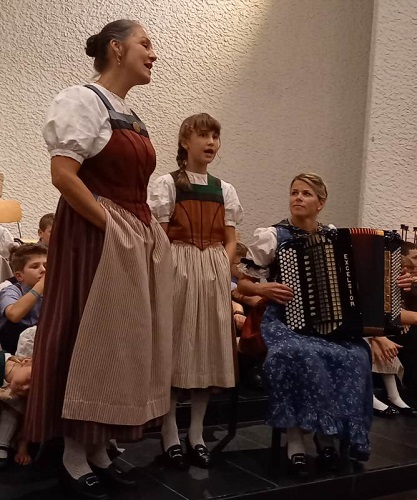 Zwei Generationen Solosängerinnen, links 
				neben Akkordeonspielerin