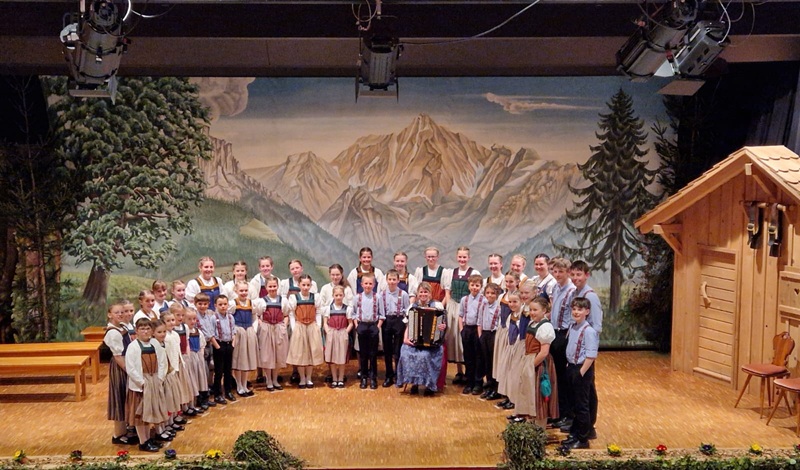 Kinderjodlercheerli singen auf der Bühne vor Bergkulisse